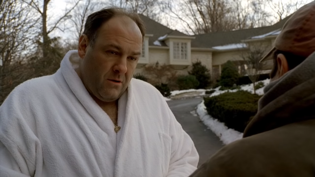 Sal Iaccuzzo in a white robe standing outside in front of man in a hat  near the building