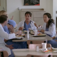 people in medical suits sitting at the table and hanging lunch and other people around them