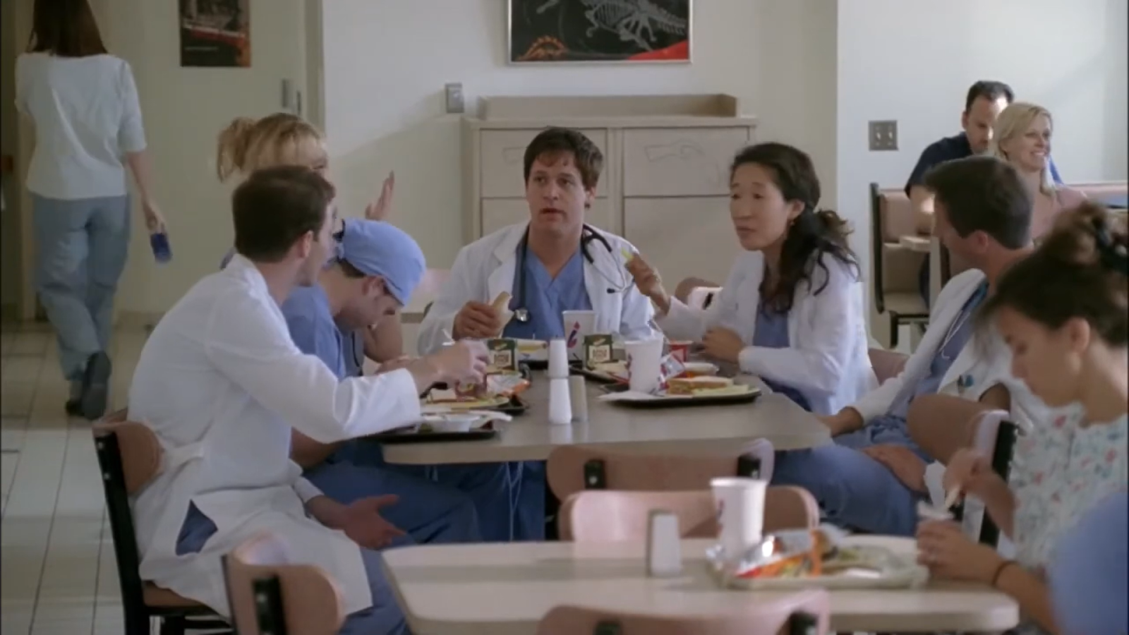 people in medical suits sitting at the table and hanging lunch and other people around them